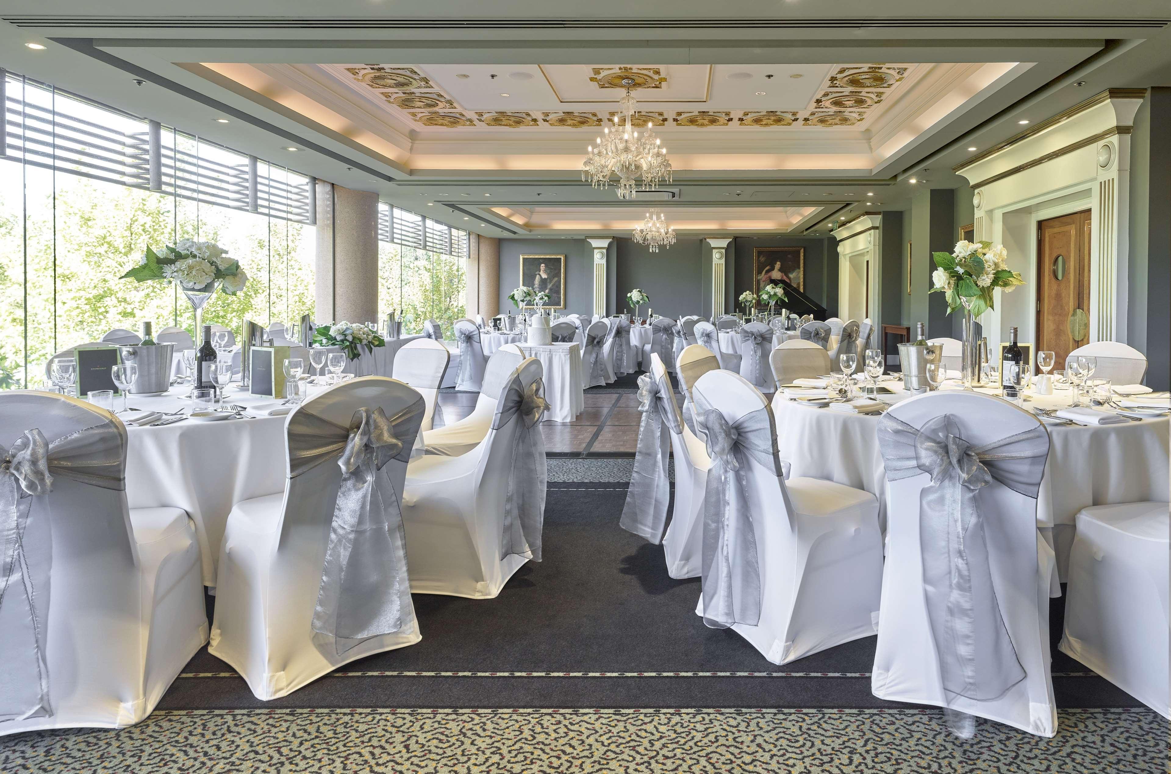 Stamford Plaza Adelaide Hotell Exteriör bild The photo displays an elegantly arranged banquet hall. The room features several round tables covered with white tablecloths, each adorned with silver sashes on the chairs. There are floral centerpieces, possibly white flowers, on the tables, adding 